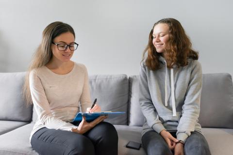 teenager talking to adult with clipboard